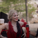 James Gunn laughs with Margot Robbie, playing Harley Quinn, in a tattered red dress.